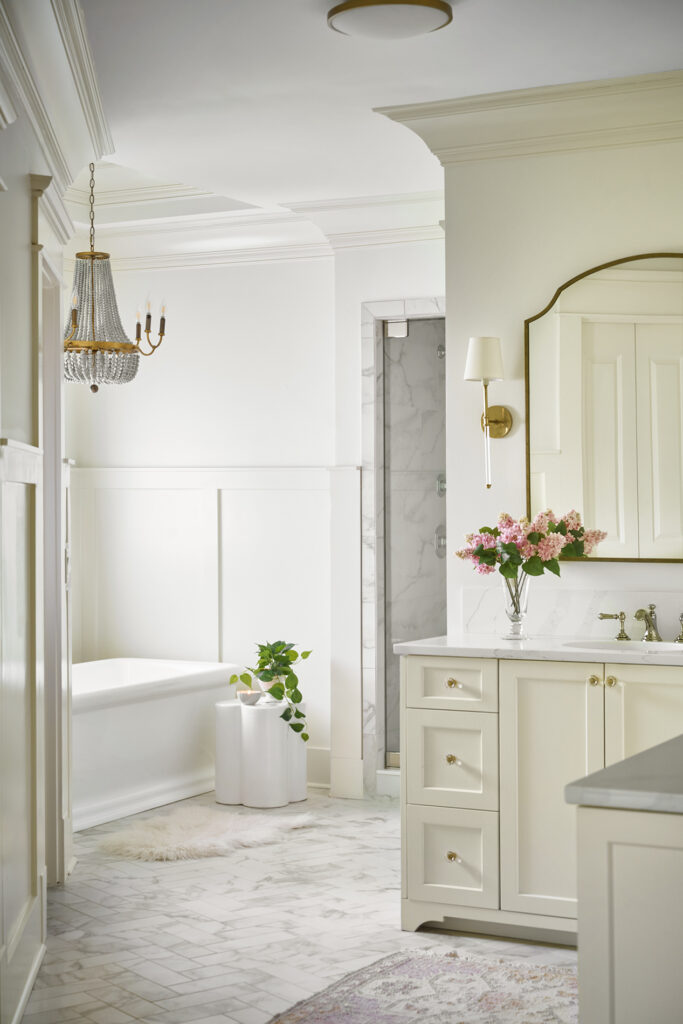 photo of classic primary bathroom showing the use of brass light fixtures, brass mirrors, and brass cabinet hardware by Atlanta interior designer.